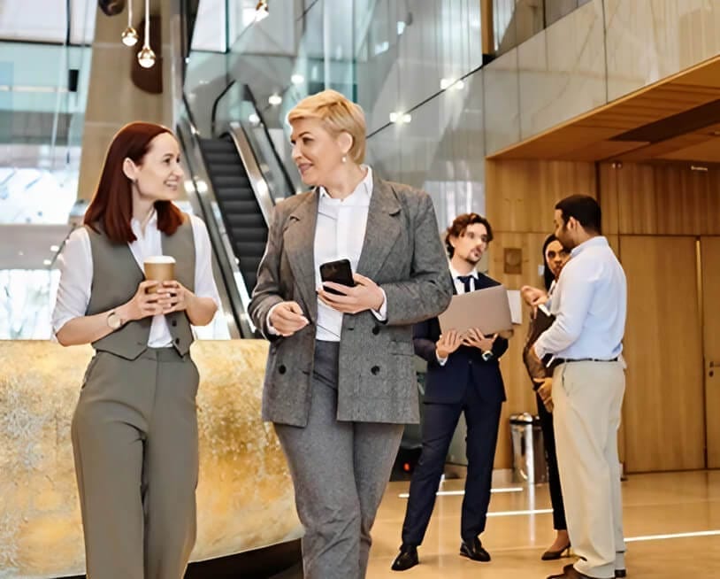 A discussion between two business individuals in a stylish lobby, highlighting professional interaction and networking.