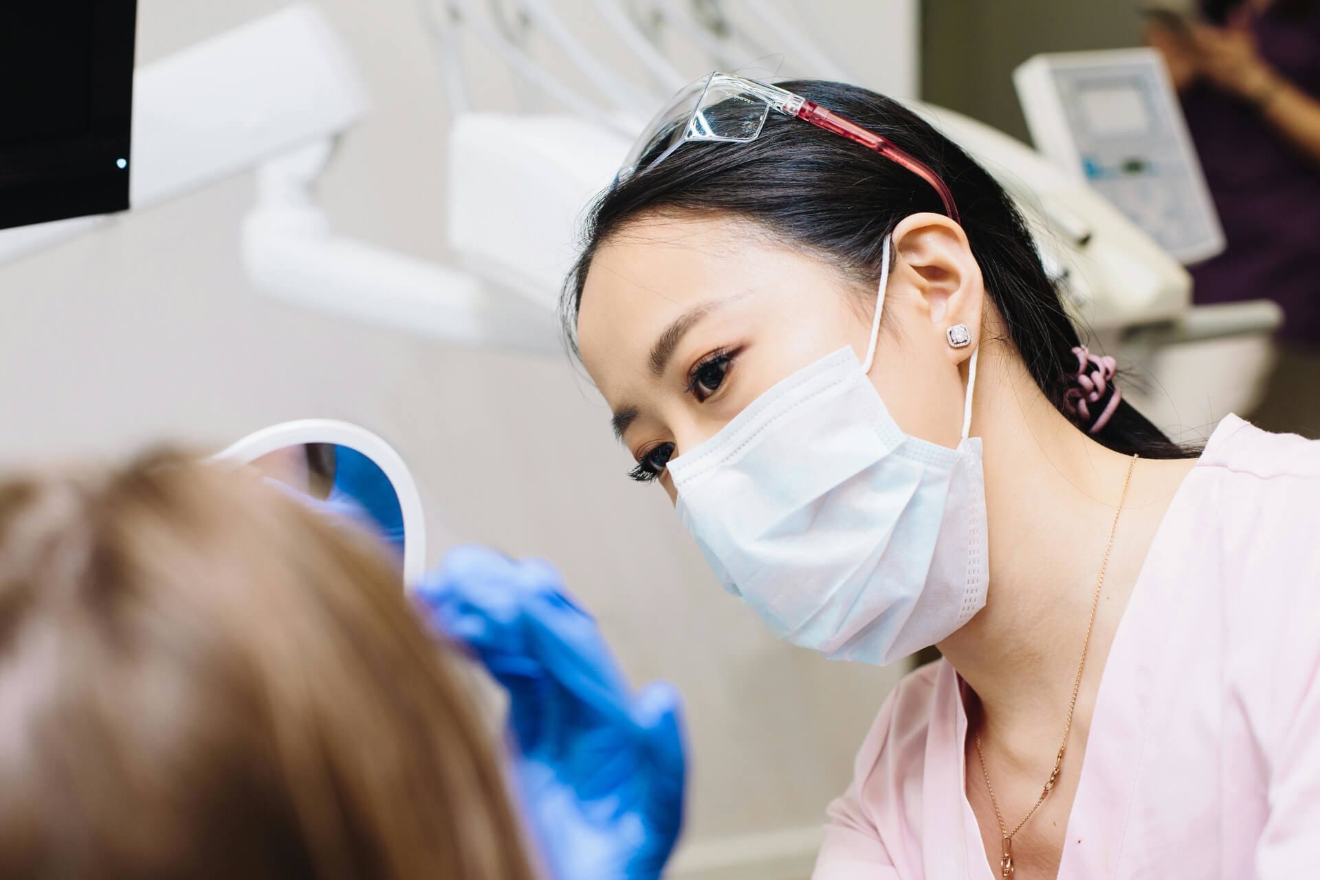 A woman with a mask is present in a dental office