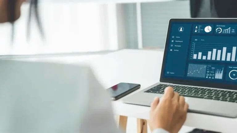 a businesswoman in her office analyzes marketing data on a lead tracking tool displayed on her laptop