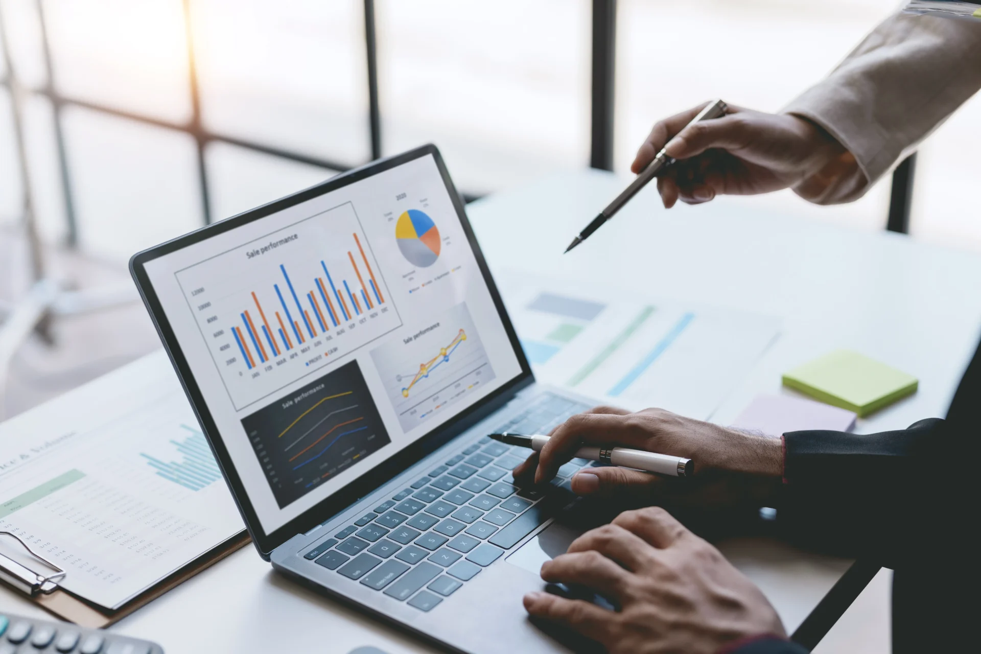 group of businesspeople meeting together analyzing and pointing laptop about business growth