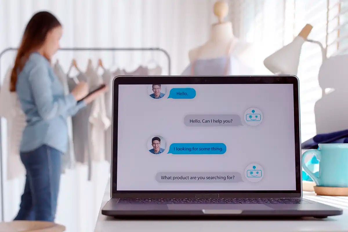 a laptop screen showing a chatbot conversation, with a person browsing clothes in the background, symbolizing online customer support in a retail setting thanks of las vegas ai services