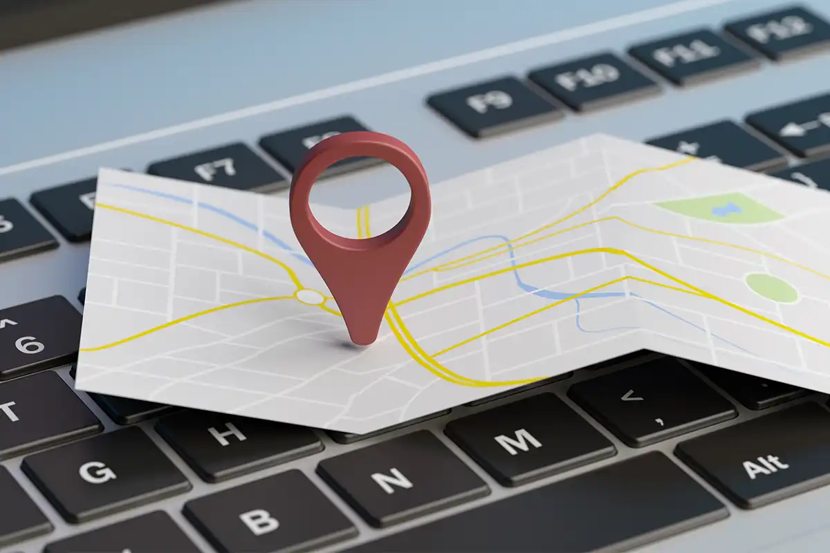 a map with a location pin icon placed on top of a keyboard, symbolizing the work of a google maps marketing agency