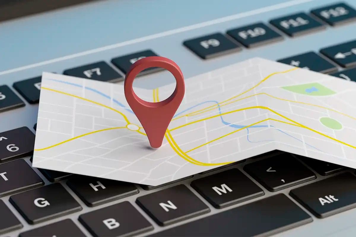 a map with a location pin icon placed on top of a keyboard, symbolizing the work of a google maps marketing agency