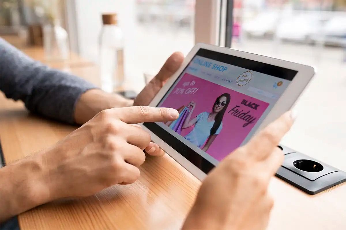 hand of young man pointing at touchpad display ad while going to enter online shop thank to the work of a display advertising company