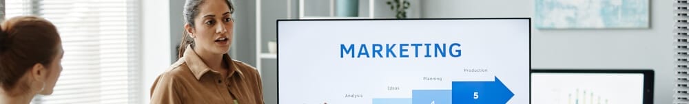 A professional presentation setting featuring a woman discussing a marketing strategy.