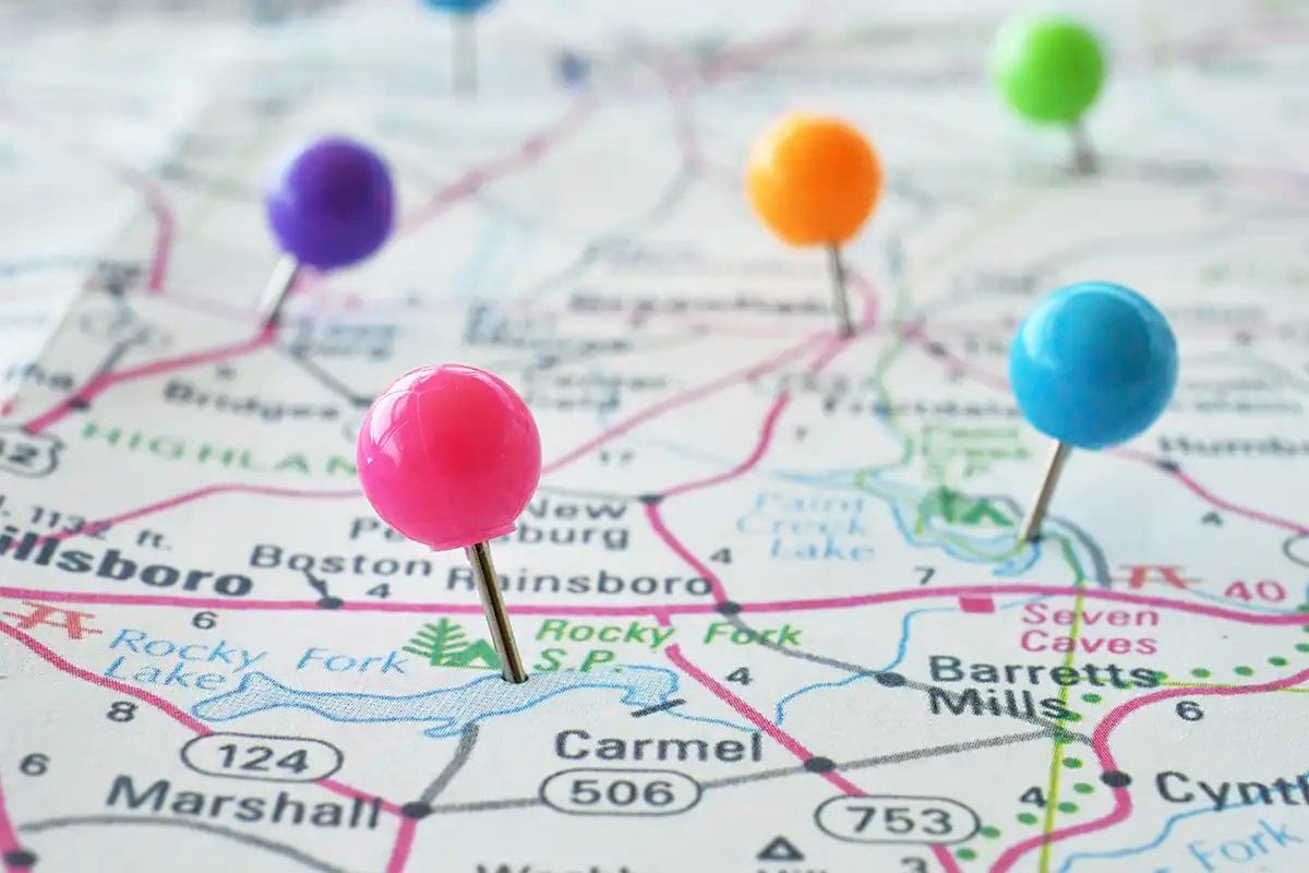 a close up view of a paper road map with colorful push pins marking various locations representing the work of google business profile management services with multiple location